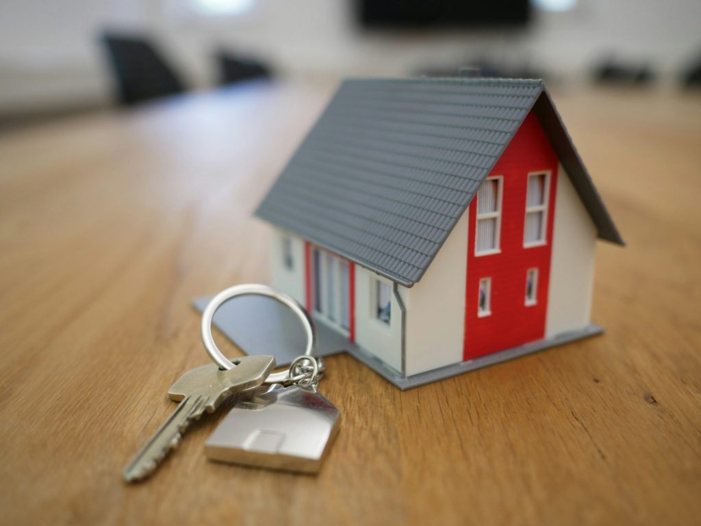 weiße und rote Holzhaus-Miniatur auf braunem Tisch